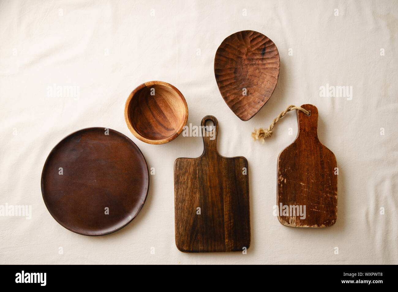 Various wooden tableware. Cutting boards, plate and bowl on linen tablecloth Stock Photo