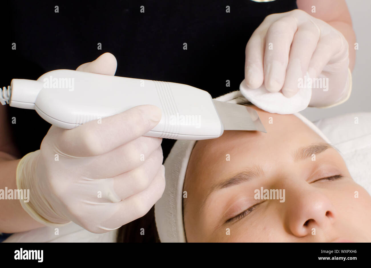 Beautiful woman receiving ultrasonic facial exfoliation procedure of