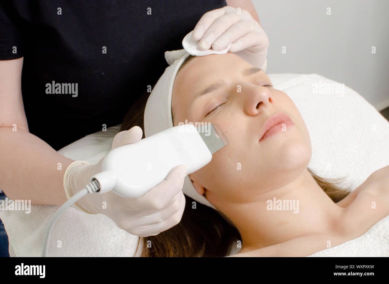 Beautiful woman receiving ultrasonic facial exfoliation procedure of