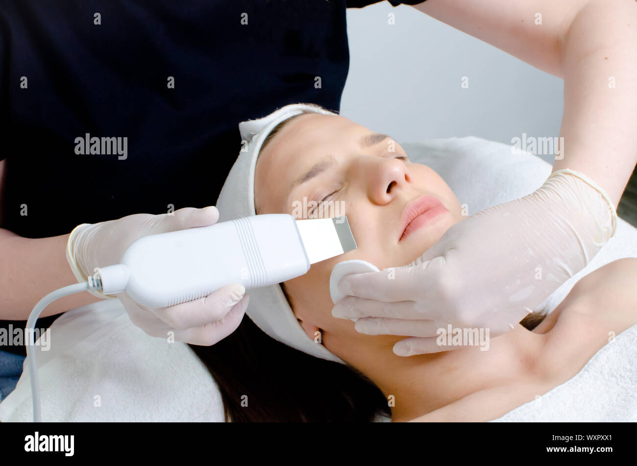 Beautiful woman receiving ultrasonic facial exfoliation procedure of