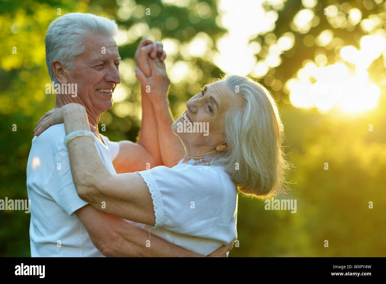 Portrait of happy beautiful senior couple dancing in summer park Stock ...