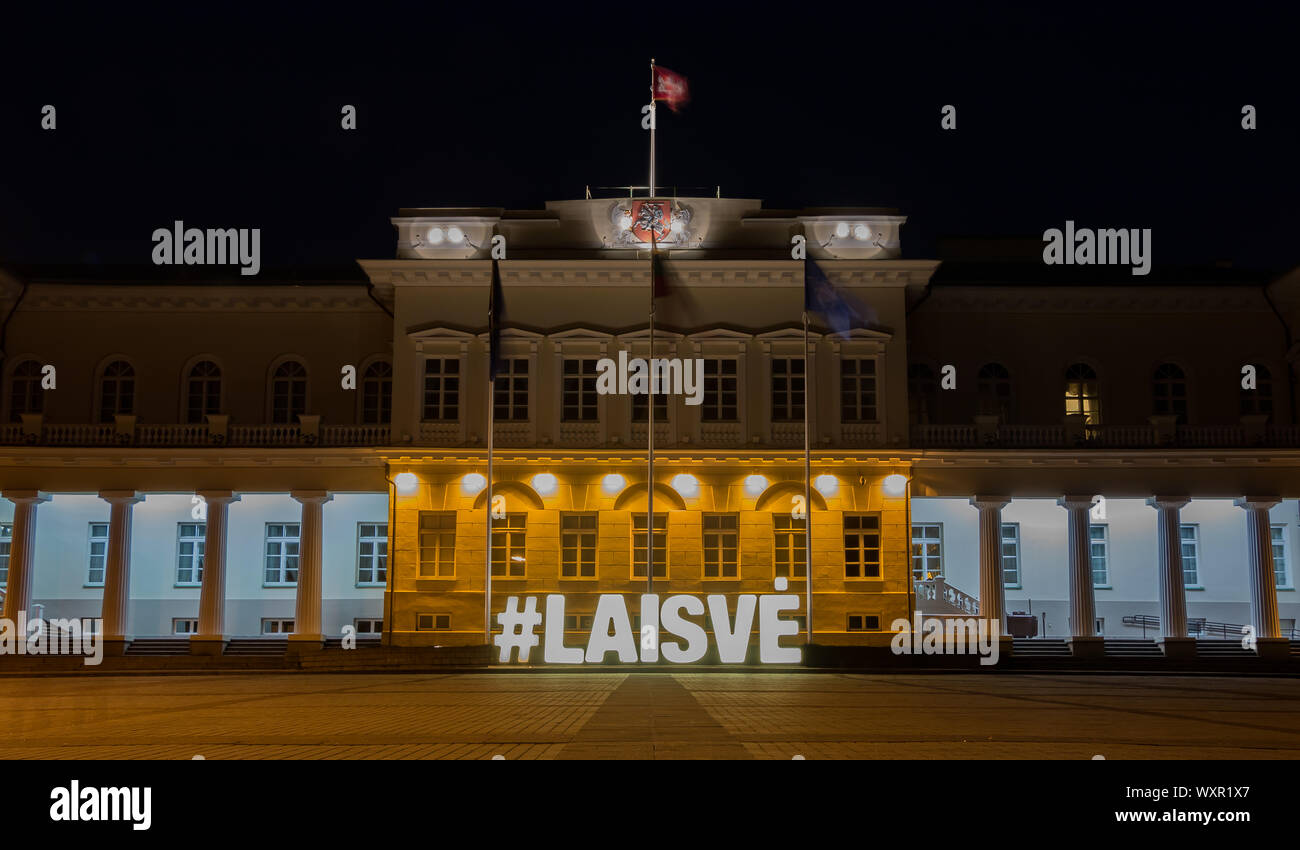 A picture of the Presidential Palace of Vilnius, at night, with a large illuminated sign that says 'Freedom'. Stock Photo