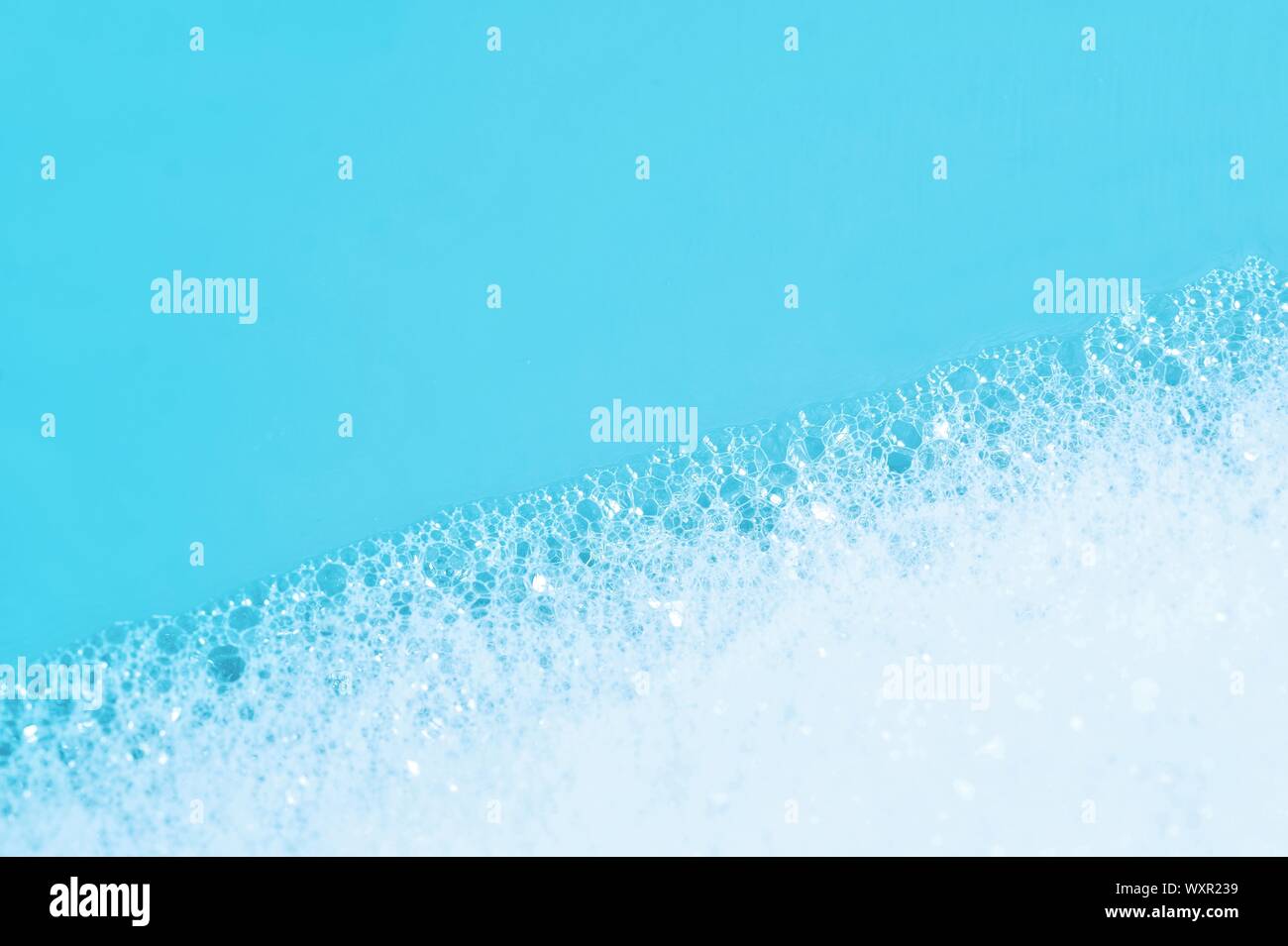 Backgrounds of blue wet soap bubbles on blue background. Laundry