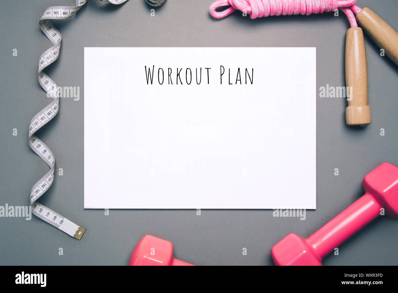 Flat lay shot of workout plan on gray background. Stock Photo