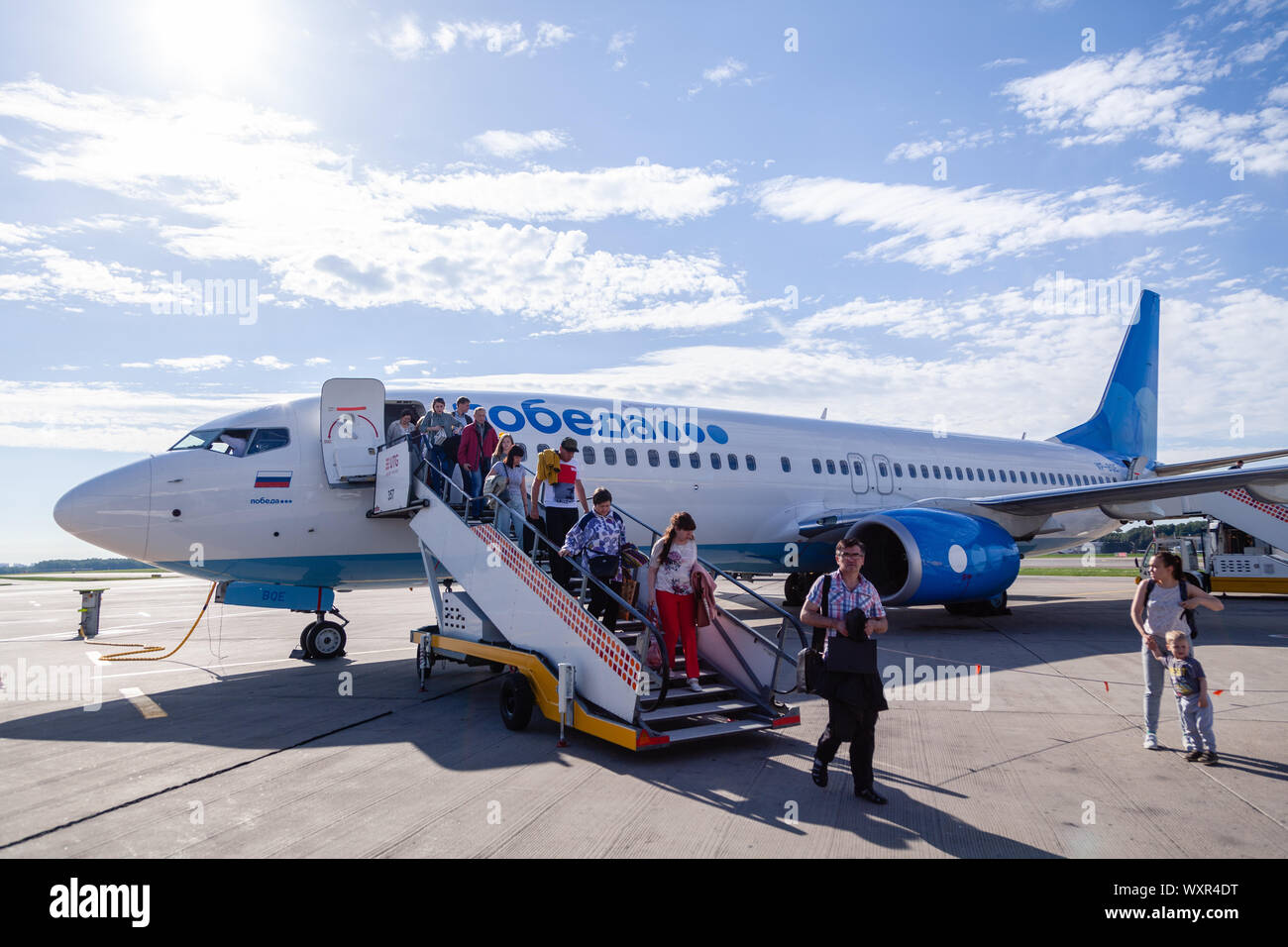 Russia Moscow 2019-06-17 Passengers of Boeing 737 Pobeda Airlines russian company low cost price comes off plane to airfield by trap. Concept travel b Stock Photo