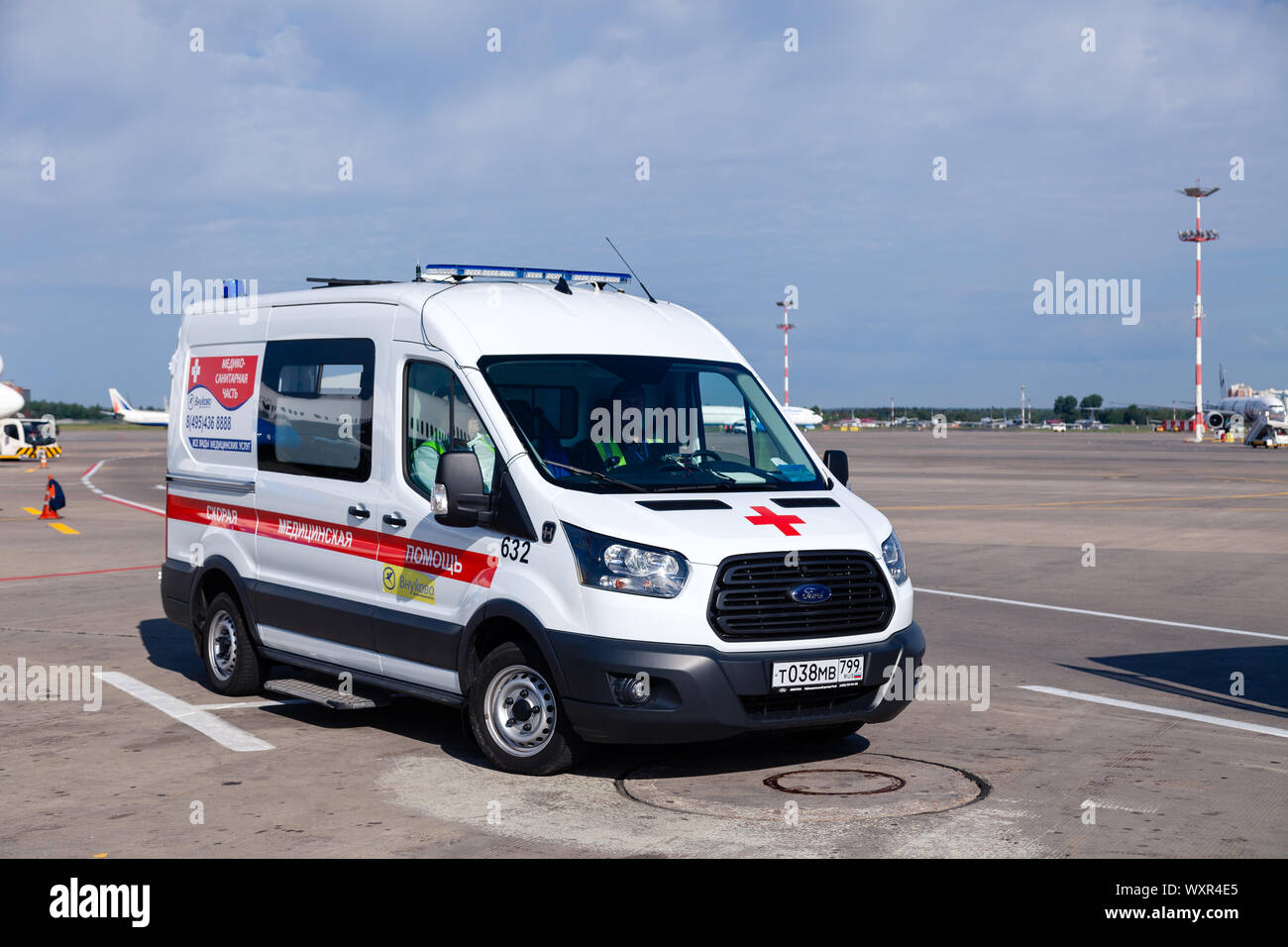 Russia Moscow 2019-06-17 Ford ambulance car on the background of the airport runway, large bus for transportation and transfer of passengers arriving Stock Photo