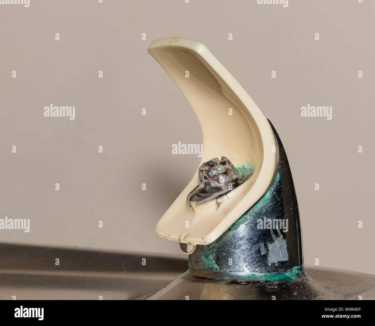 Old drinking water fountain leaking water at spout causing unhealthy mold to grow Stock Photo