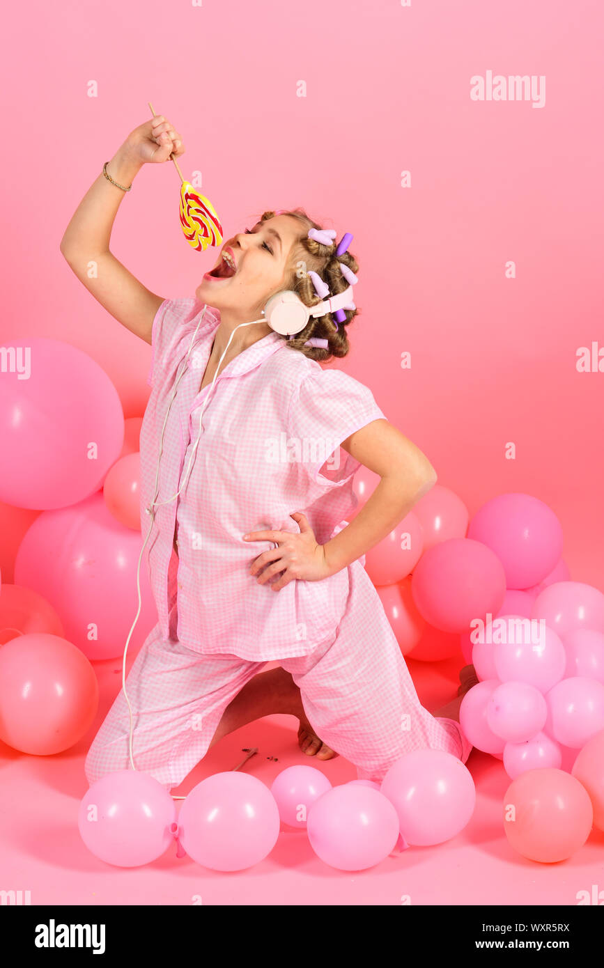 Cute happy little girl with lollipop candy in front of colorful pink background Stock Photo