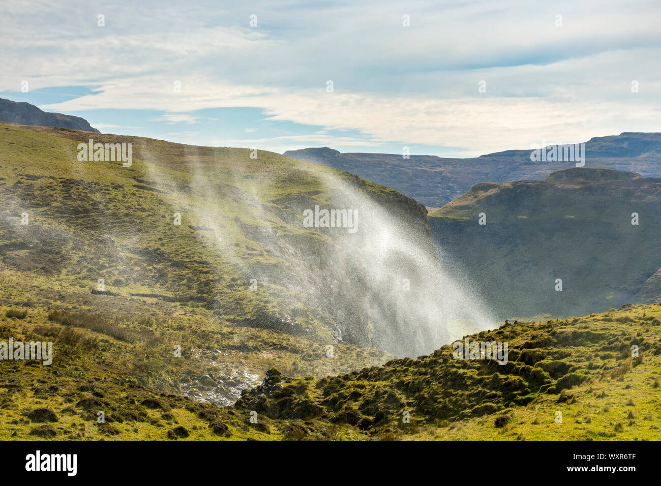 Spray from the Allt Mheididh waterfall being blown upwards by the wind, Talisker Bay, Minginish, Isle of Skye, Scotland, UK Stock Photo