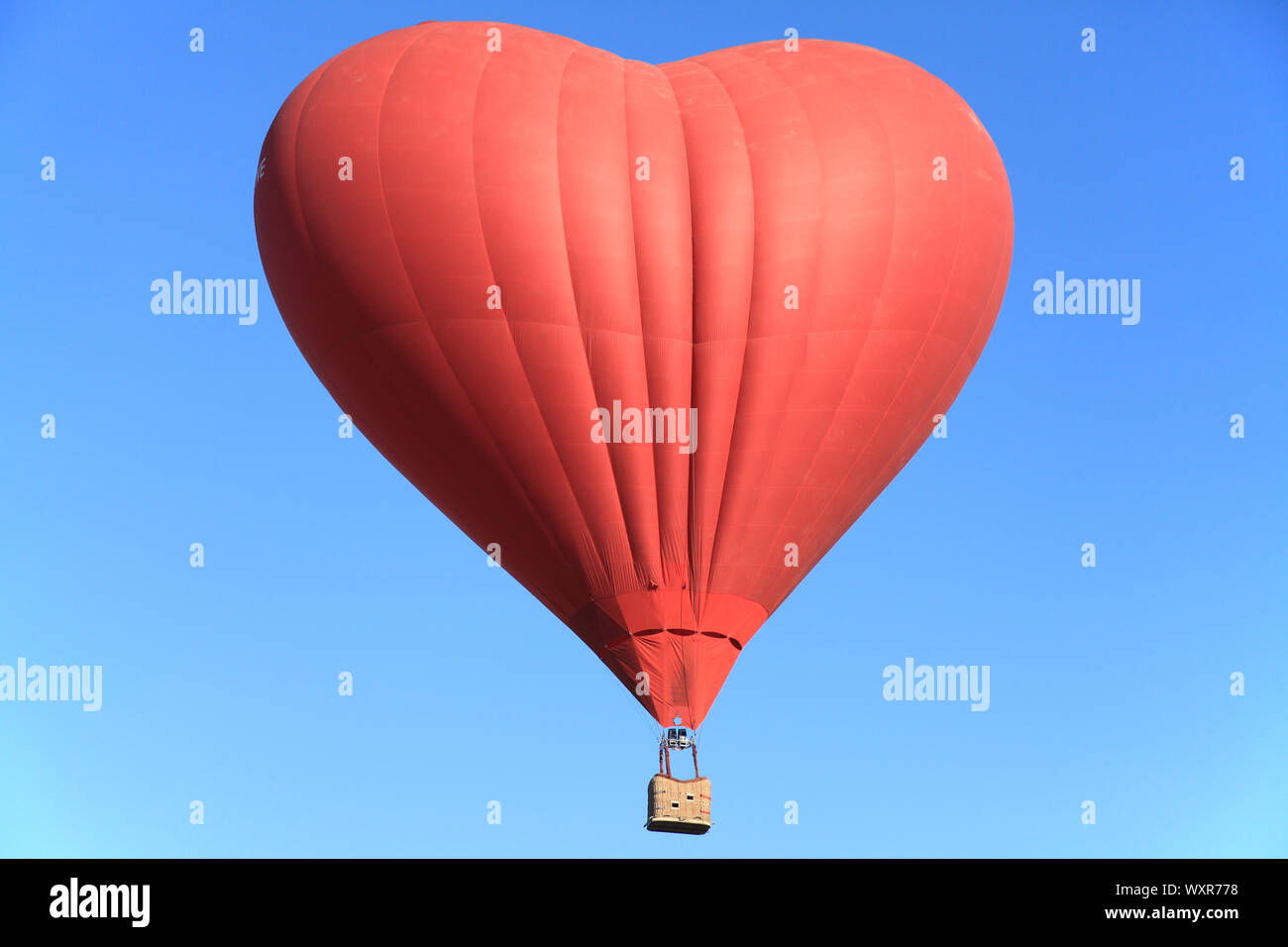 St. Valentine's day. The red heart in the blue sky. Flight on a hot air ...