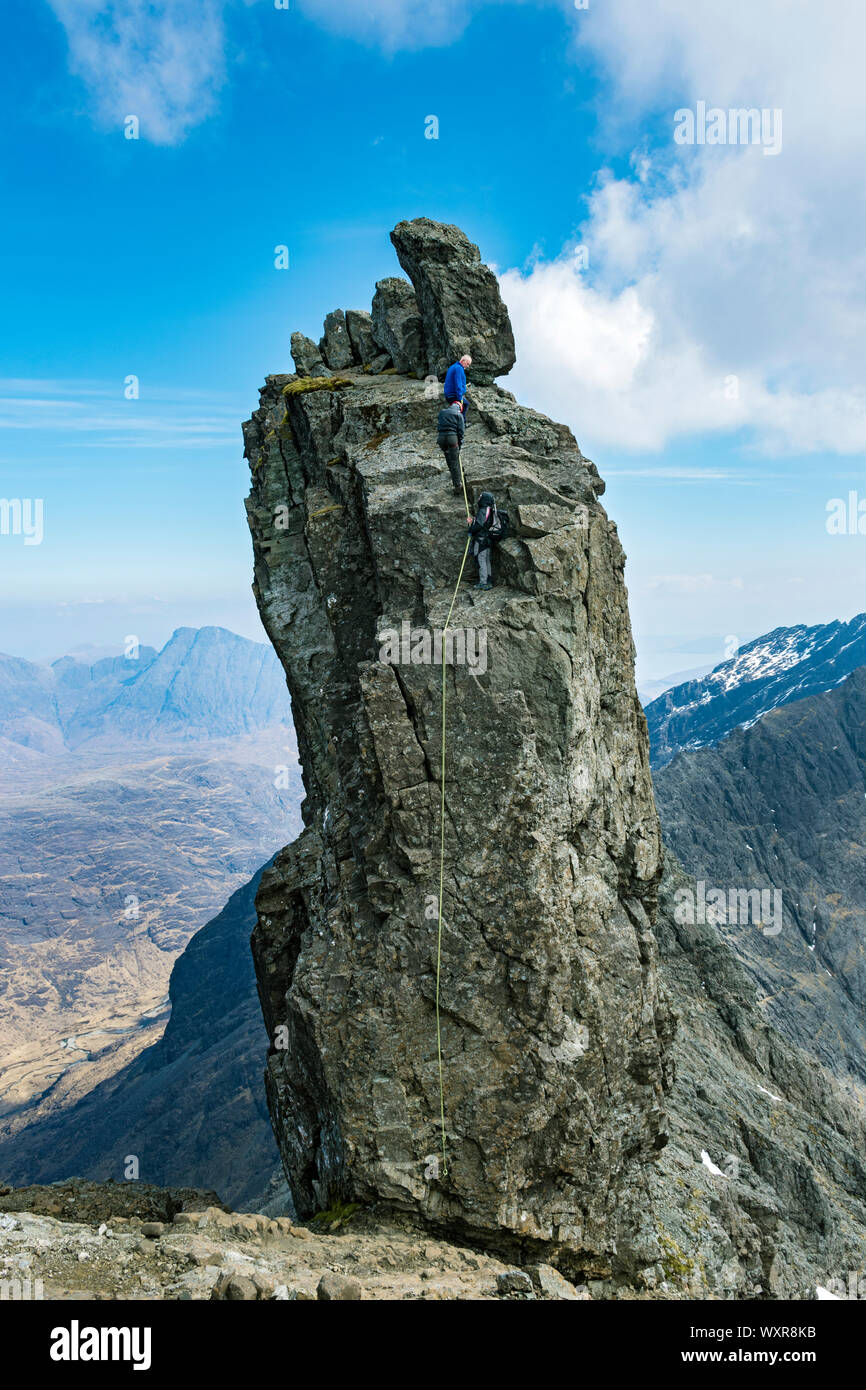Climbers preparing to abseil off the Inaccessible Pinnacle, at the summit of Sgurr Dearg, Cuillin mountains, Minginish, Isle of Skye, Scotland, UK Stock Photo