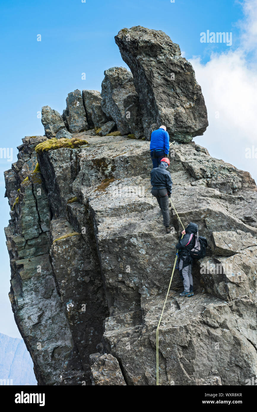Climbers preparing to abseil off the Inaccessible Pinnacle, at the summit of Sgurr Dearg, Cuillin mountains, Minginish, Isle of Skye, Scotland, UK Stock Photo