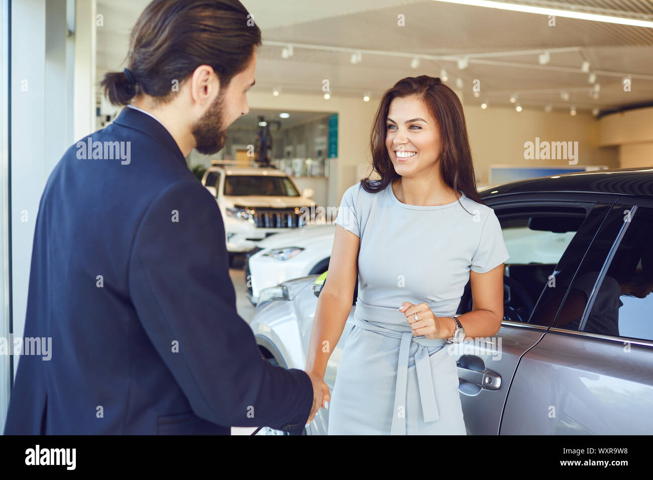 Girl buyer shakes hands dealer a car Stock Photo