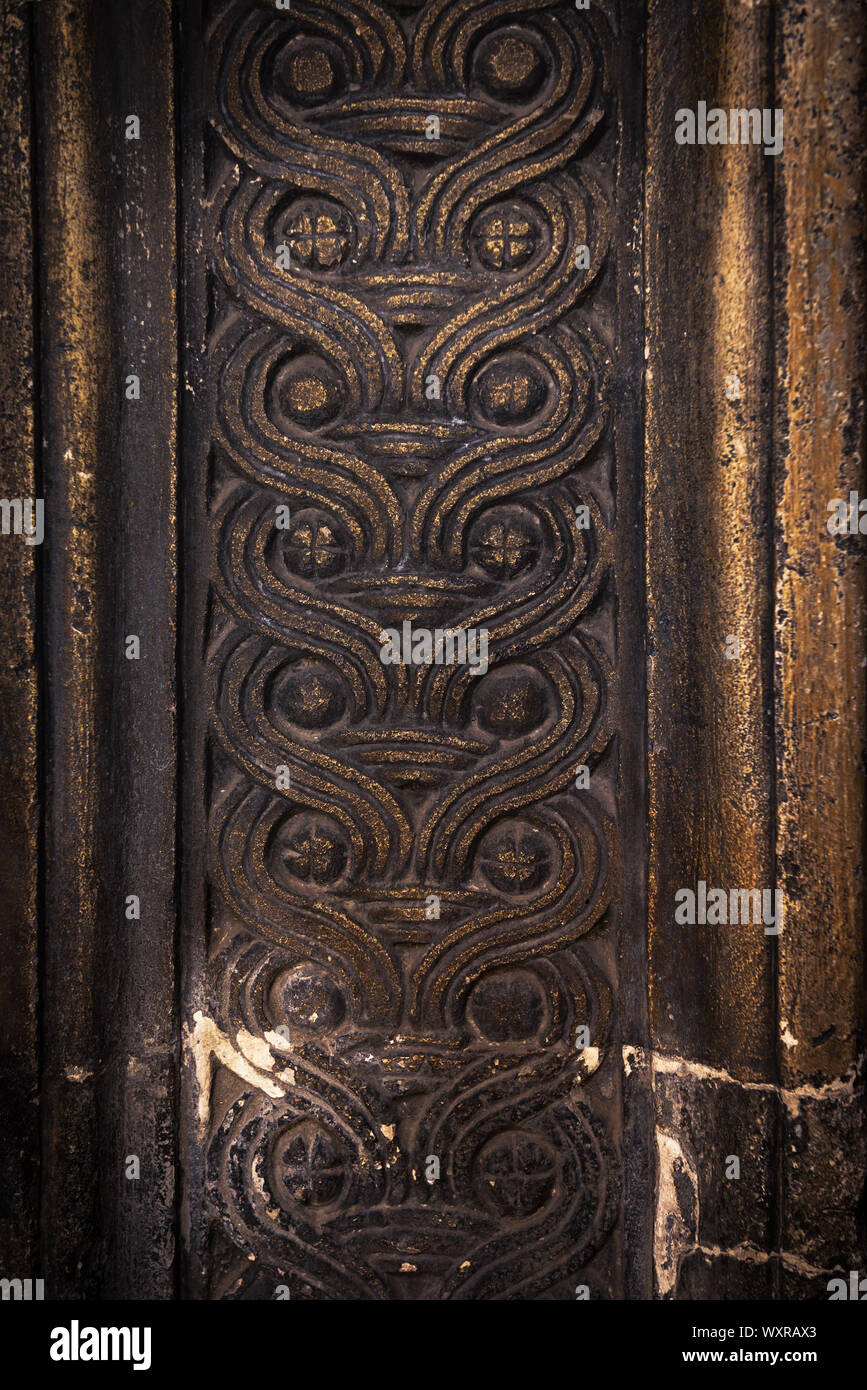 Ancient columns with Renaissance bas-reliefs and plants patterns in the wall Stock Photo