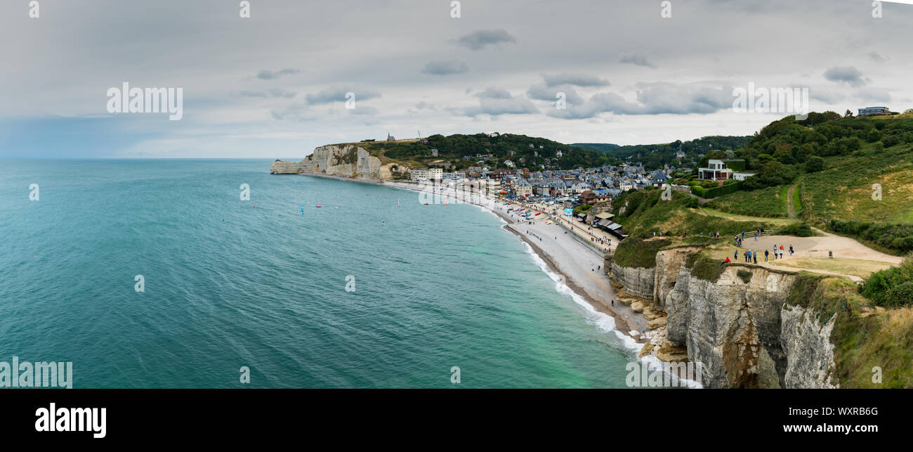 Etretat, Seine-Maritime / France - 14 August 2019:  tourists enjoy hiking on the Normandy coast along the Falaise de Etretat cliffs above the village Stock Photo