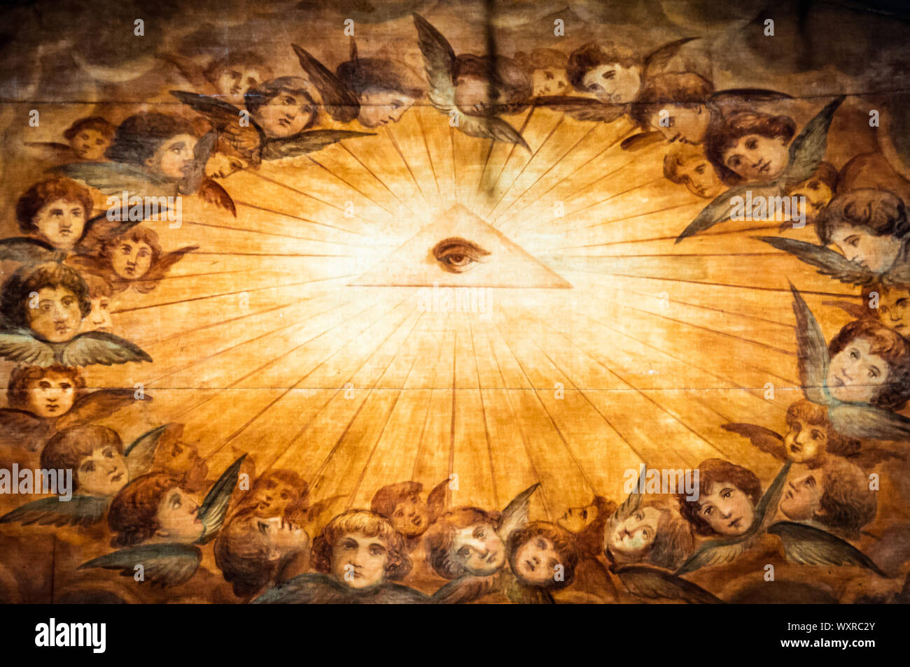 Close up view of the eye of providence, or all-seeing eye of god, symbol surrounded by angels that can be seen in some European churches.  Eye can be Stock Photo