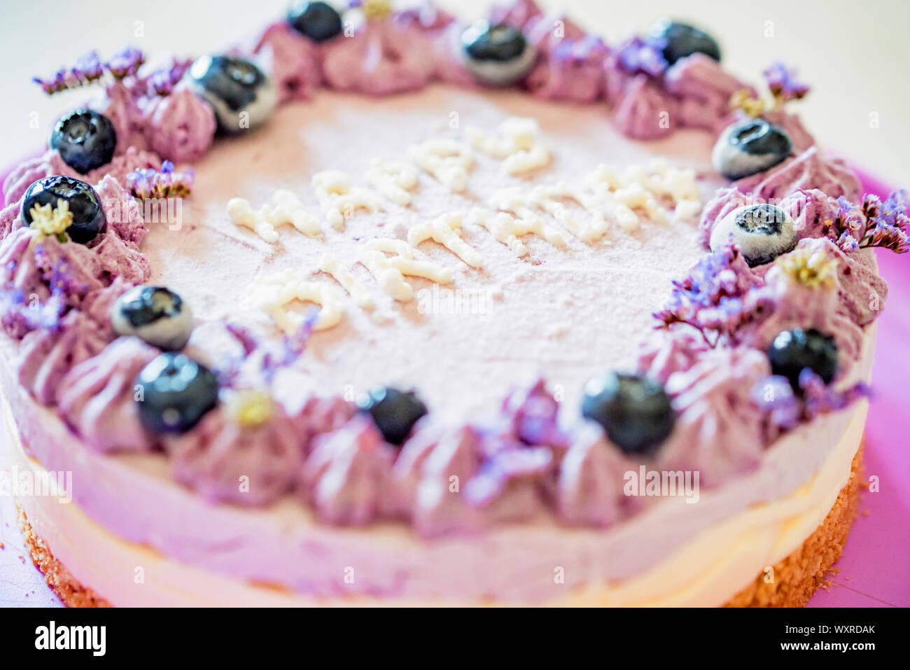 Close Image Of Layer Cake With Purple Cream And Blueberries Saying