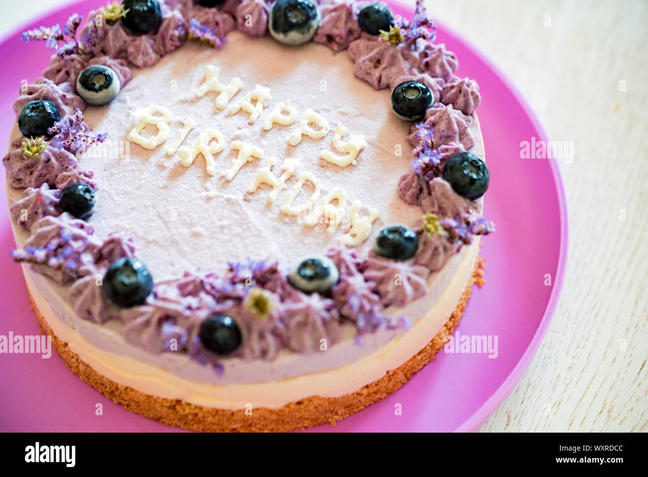 Close Image Of Layer Cake With Purple Cream And Blueberries Saying
