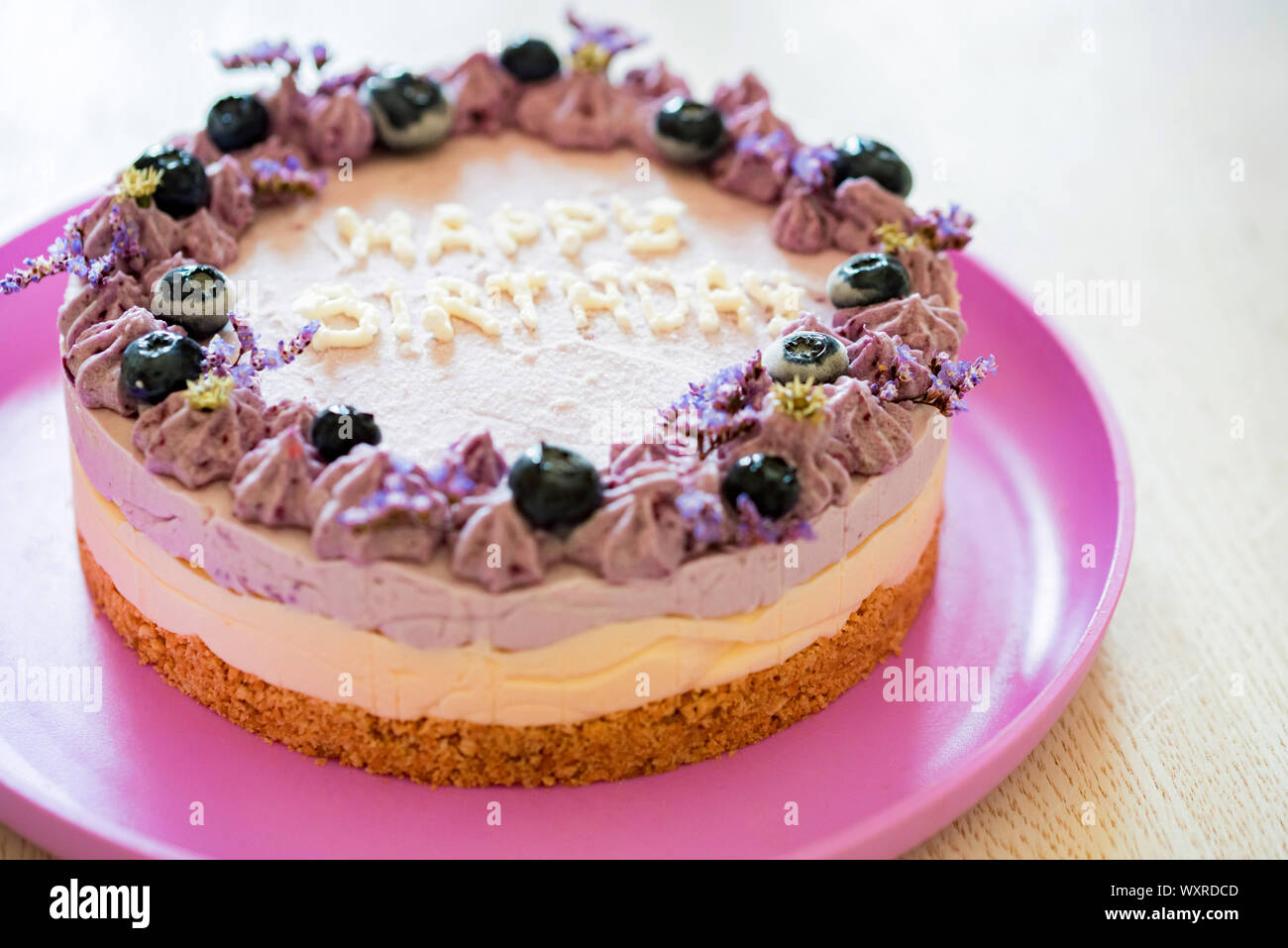 Close Image Of Layer Cake With Purple Cream And Blueberries Saying