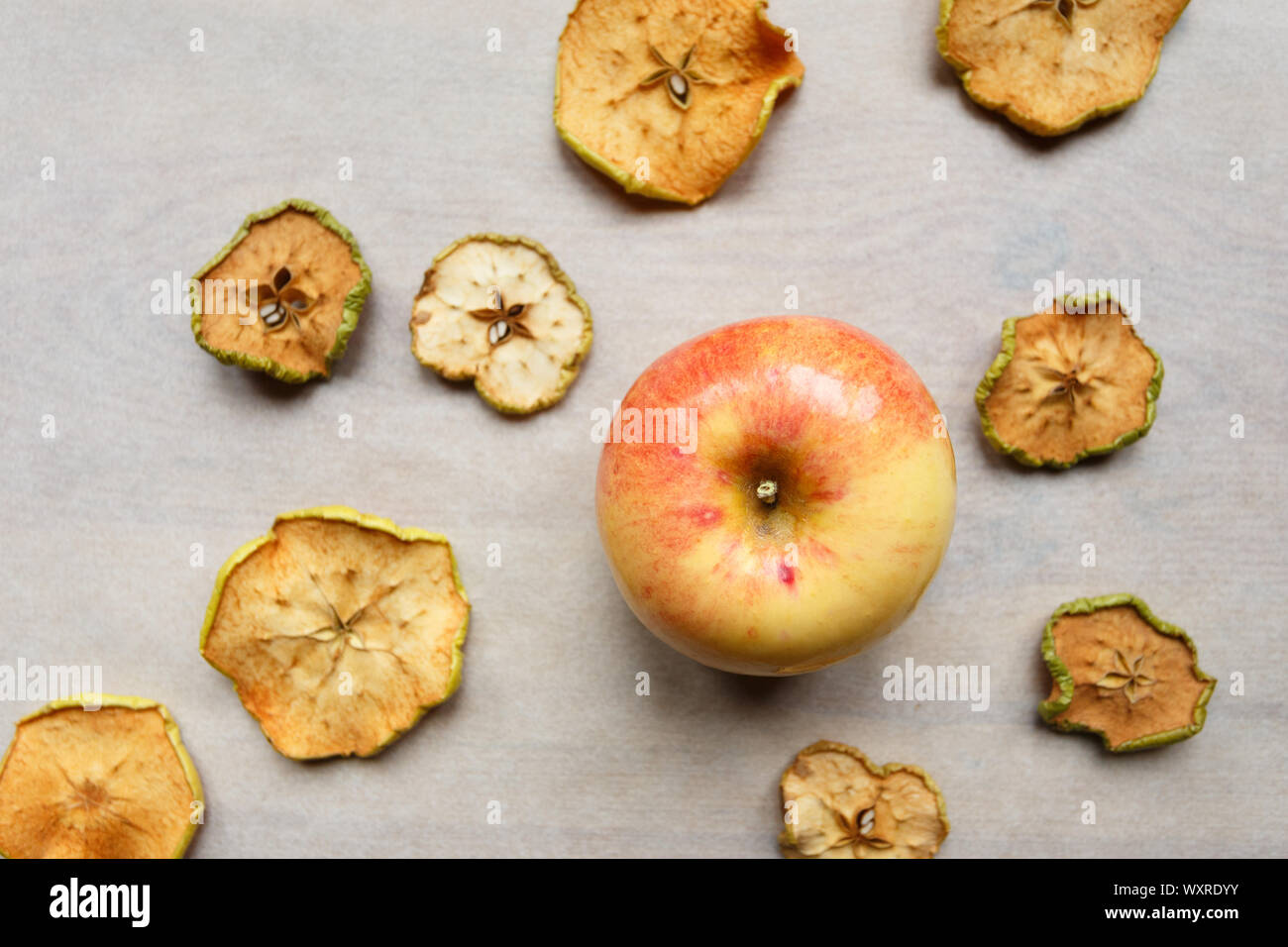 Fresh apple with pieces of dry apples on the table, top view Stock Photo