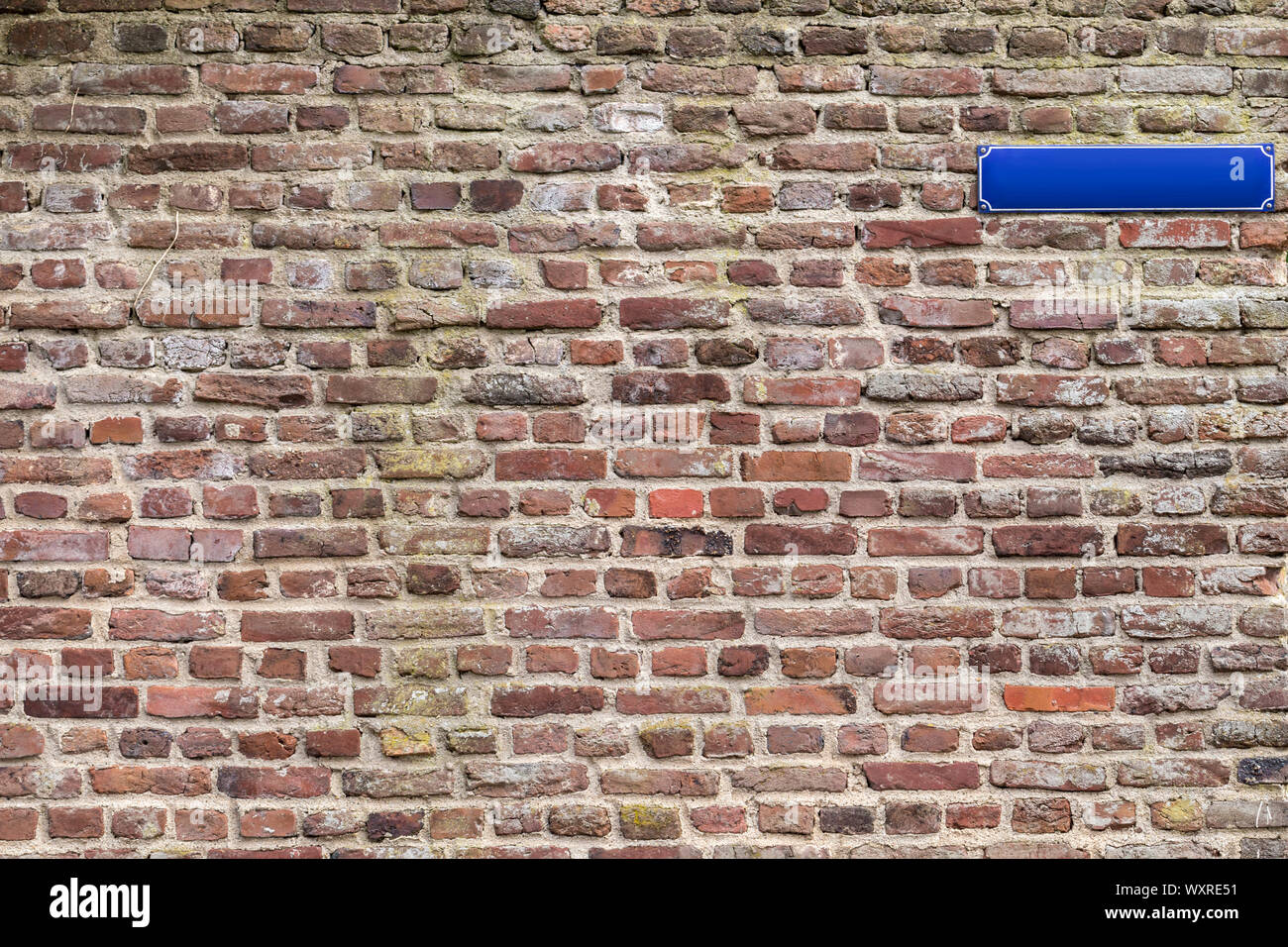 Old brick walling background/template with empty street sign for own type. Brick wall without street sign is also available. Stock Photo