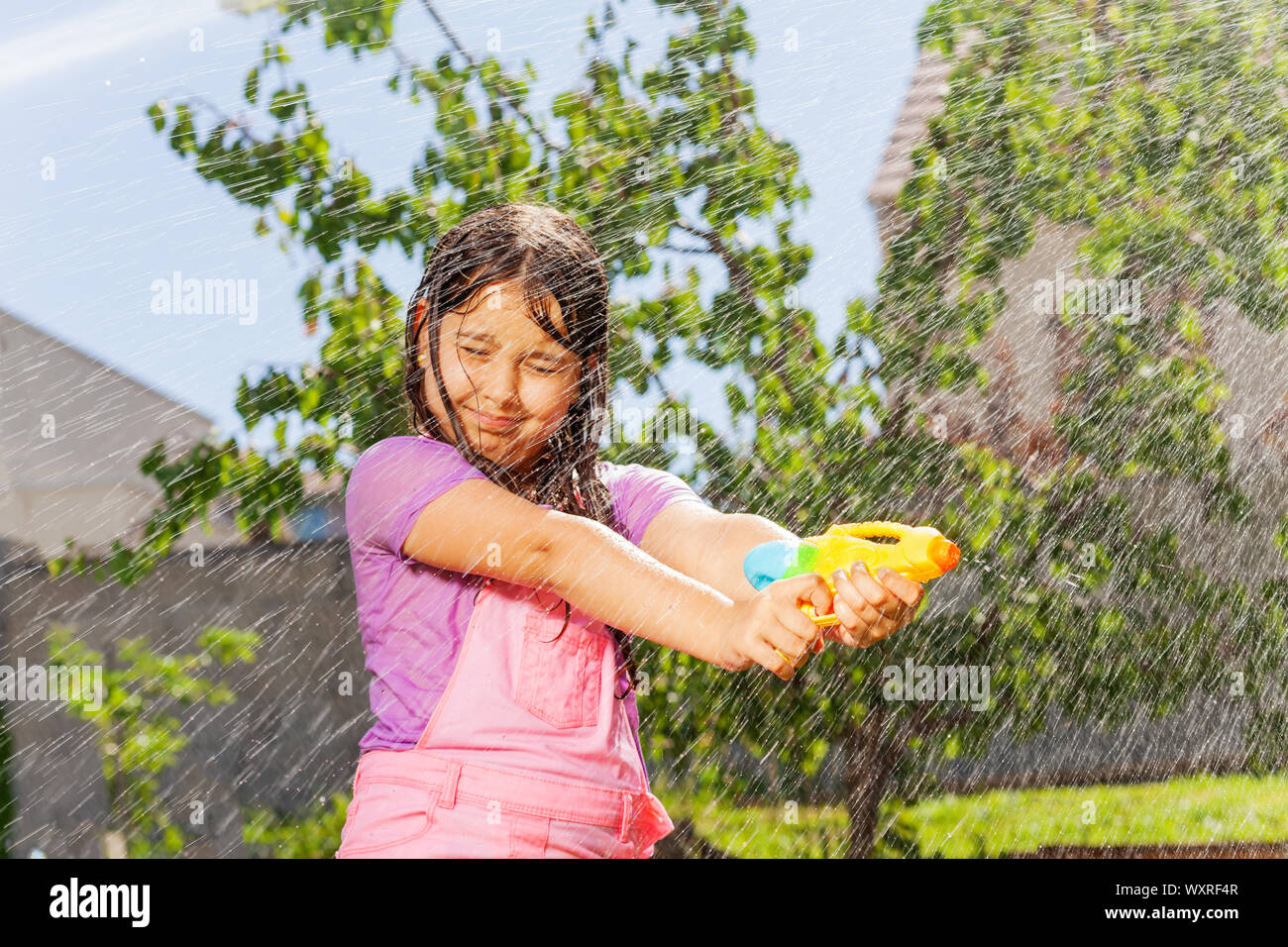 Little girl with wet hair in water gun fight game Stock Photo Alamy