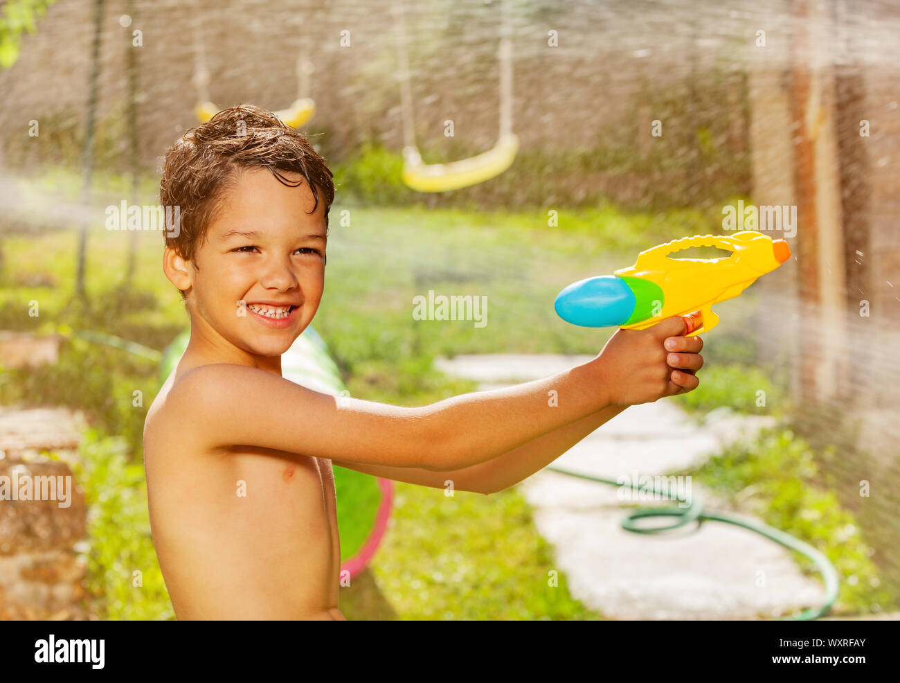 Active aggressive boy play water gun fight game Stock Photo Alamy