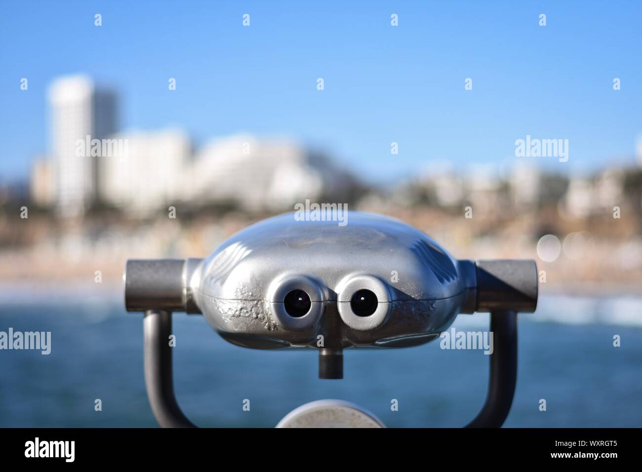 View of Santa Monica city skyline from the pier from behind a coin operated steel viewing machine, binoculars, hi-spy. Stock Photo