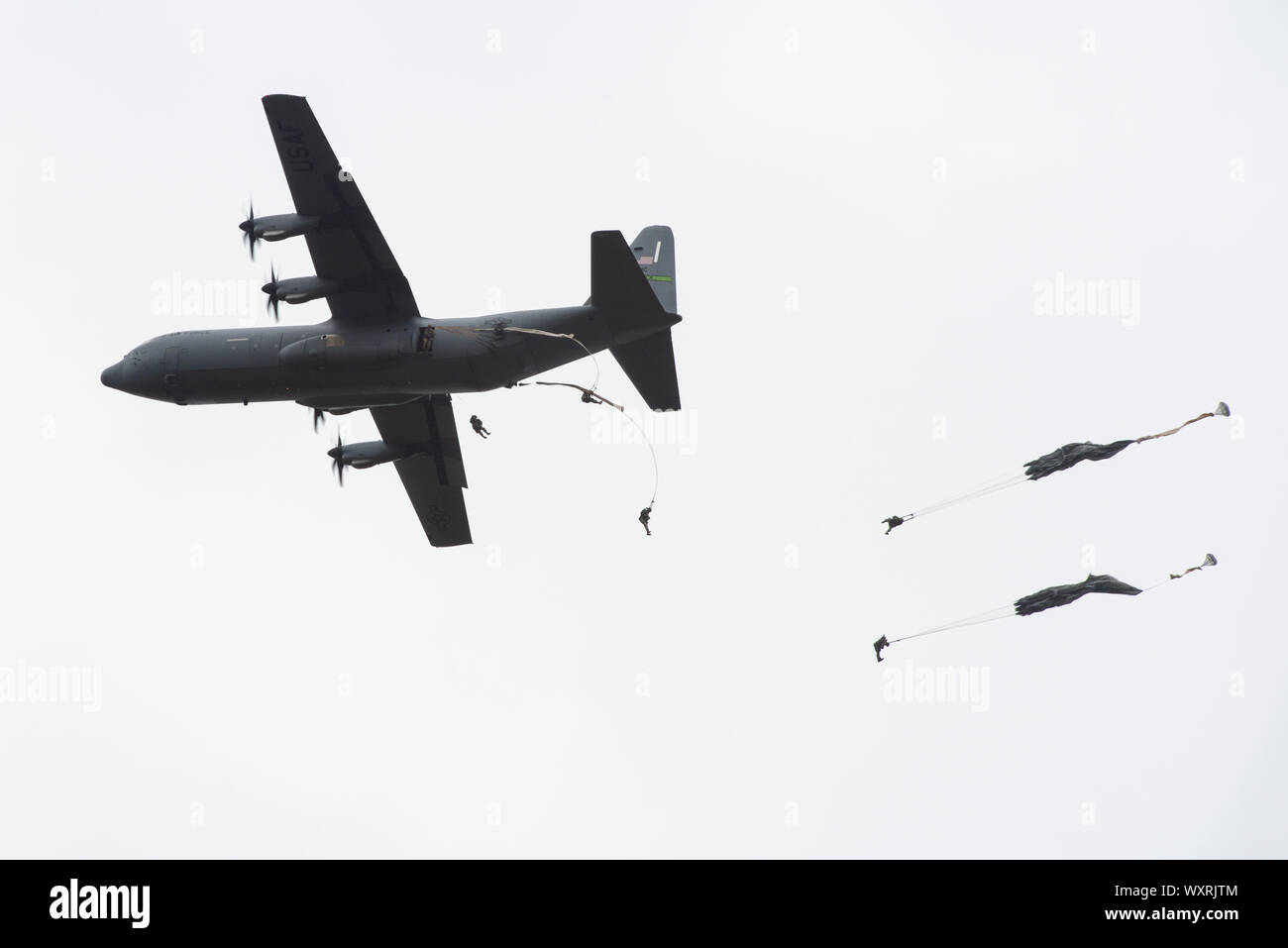 Army paratroopers with the 4th Infantry Brigade Combat Team (Airborne), 25th Infantry Division, U.S. Army Alaska, jump from an Air Force C-130J Super Hercules during airborne operations at Joint Base Elmendorf-Richardson, Alaska, Sept. 16, 2019. The Soldiers of 4/25 belong to the only American airborne brigade in the Pacific and are trained to execute airborne maneuvers in extreme cold weather and high altitude environments in support of combat, partnership and disaster relief operations. (U.S. Air Force photo by Alejandro Peña) Stock Photo