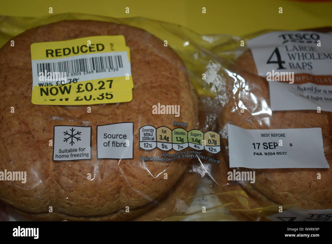 4 Wholemeal rolls double price reduction to 27p on a yellow and white background with the Tesco brand on it. Stock Photo