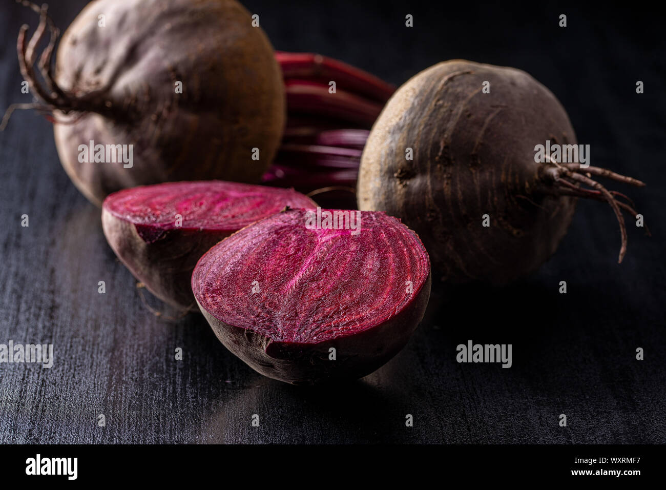 Tasty raw beetroot. Sliced beetroot on black kitchen table. Stock Photo