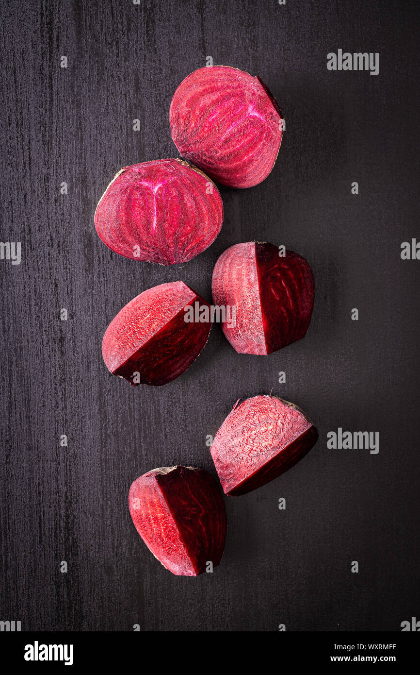 Tasty raw beetroot. Sliced beetroot on black kitchen table. Top view. Stock Photo