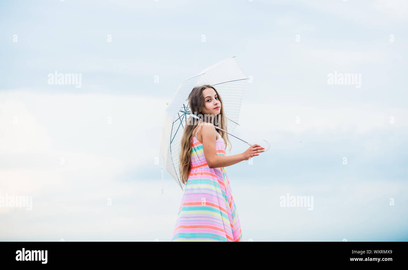 Happy childhood. I believe i can fly. Touch sky. Fairy tale character. Feeling light. Girl with light umbrella. Anti gravitation. Fly drop parachute. Dreaming about first flight. Kid pretending fly. Stock Photo