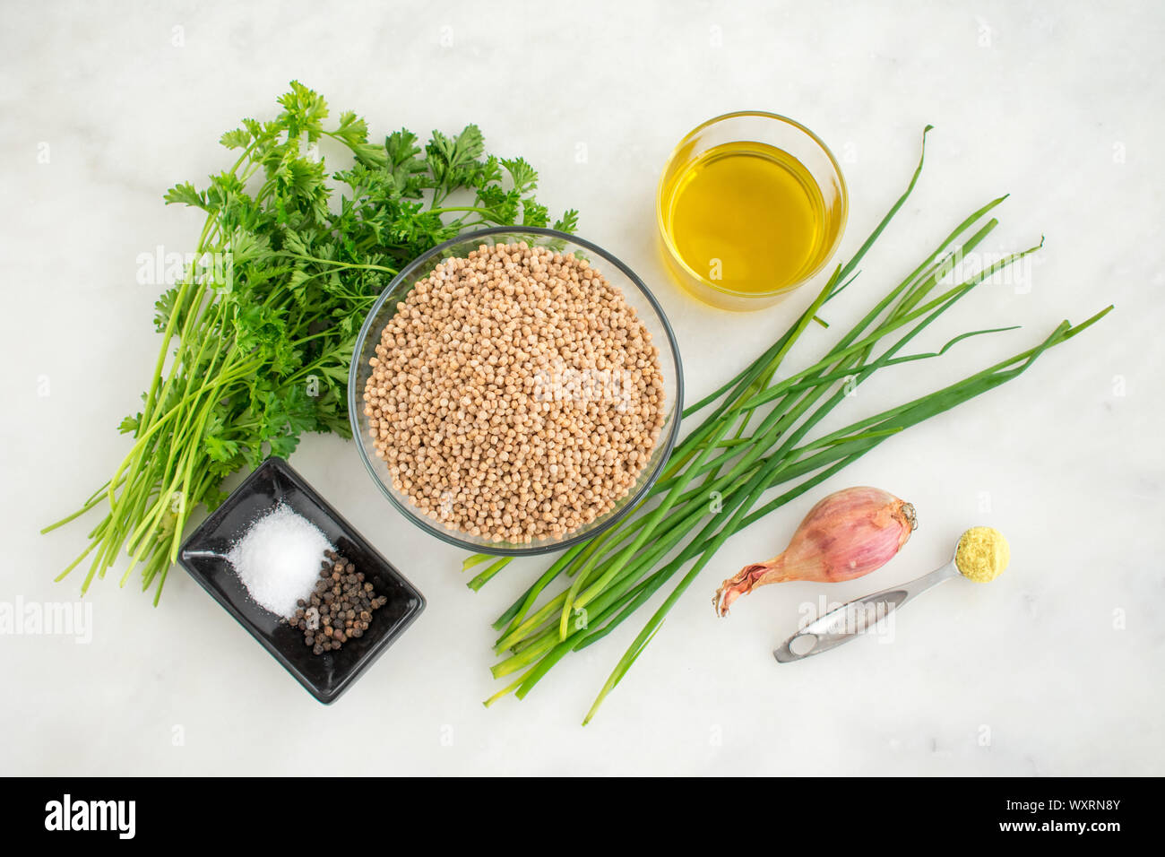 Herbed Couscous Pilaf with Chives Ingredients: Whole wheat pearl couscous, fresh herbs, and other ingredients used to make a savory side dish. Stock Photo