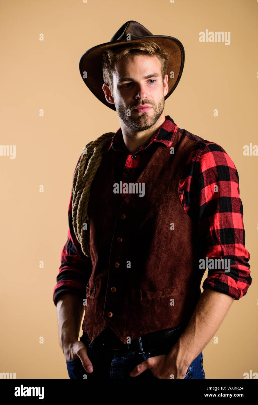 Unshaven guy in cowboy hat. Handsome bearded macho. Cowboy wearing hat
