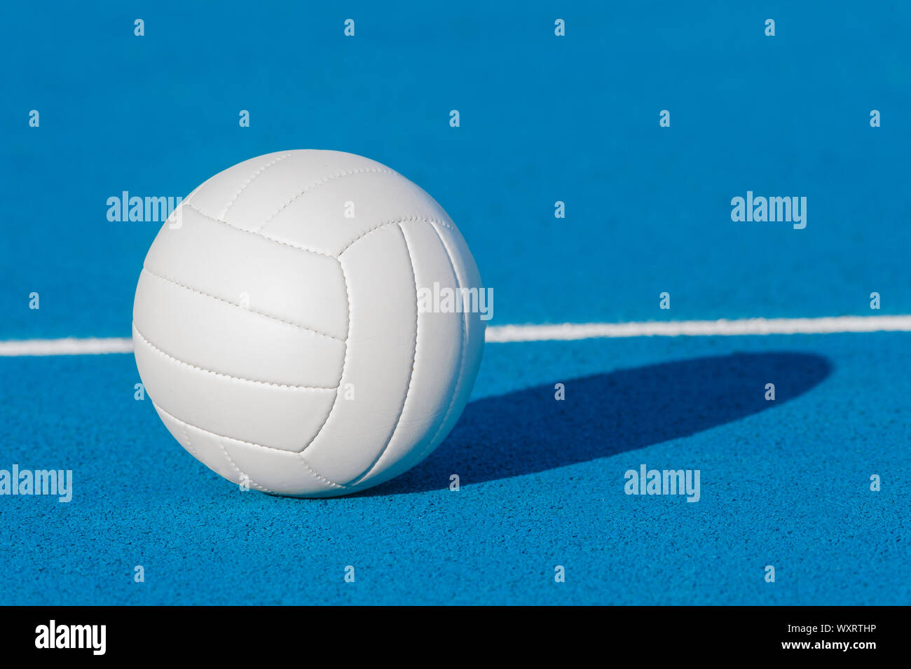Volleyball ball on blue playground with white line Stock Photo - Alamy