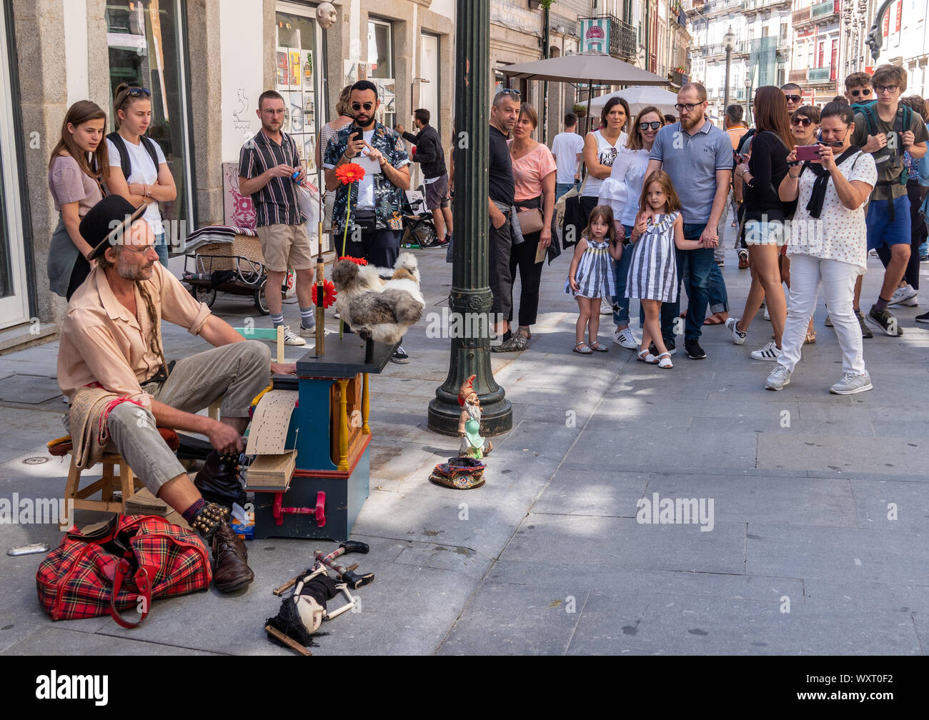 Busker playing a card based music box player in Portugal Stock Photo - Alamy