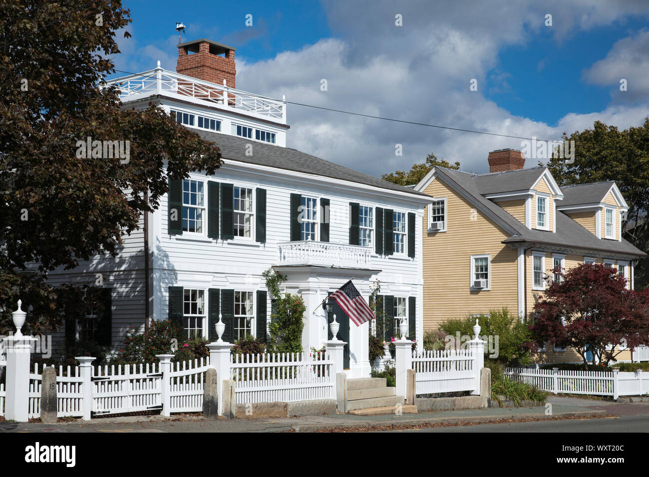 Elegant traditional wooden clapboard house with patriotic Stars and Stripes flag at Manchester-by-the-Sea. Massachusetts, USA Stock Photo