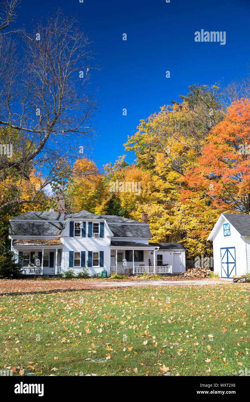 Neat traditional, typical wooden white clapboard house surrounded by Fall foliage, in Conway, New Hampshire, USA Stock Photo