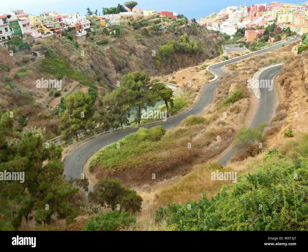 Extreme narrow winding route along a Barranco above the city of Los Realejos in the north of the Canary Island of Tenerife overlooking the colorful ho Stock Photo