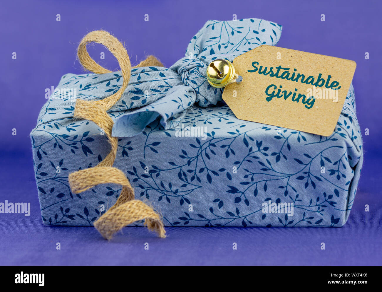 Fabric wrapped gift with sustainable giving label, reusable sustainable