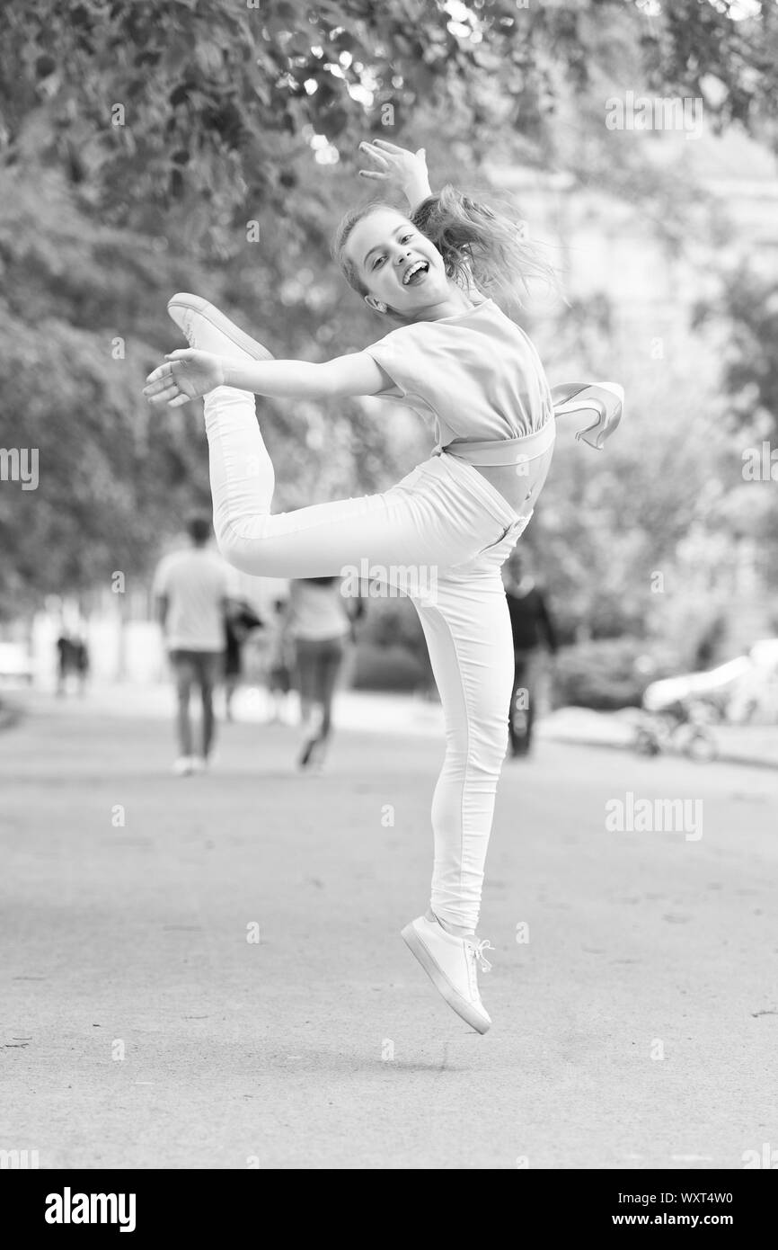 I am dancing roll up the floor. Dancing girl. Adorable dancer feeling free  on city street. Small child enjoy dancing to modern music. Energetic little  girl dancing with pleasure Stock Photo -