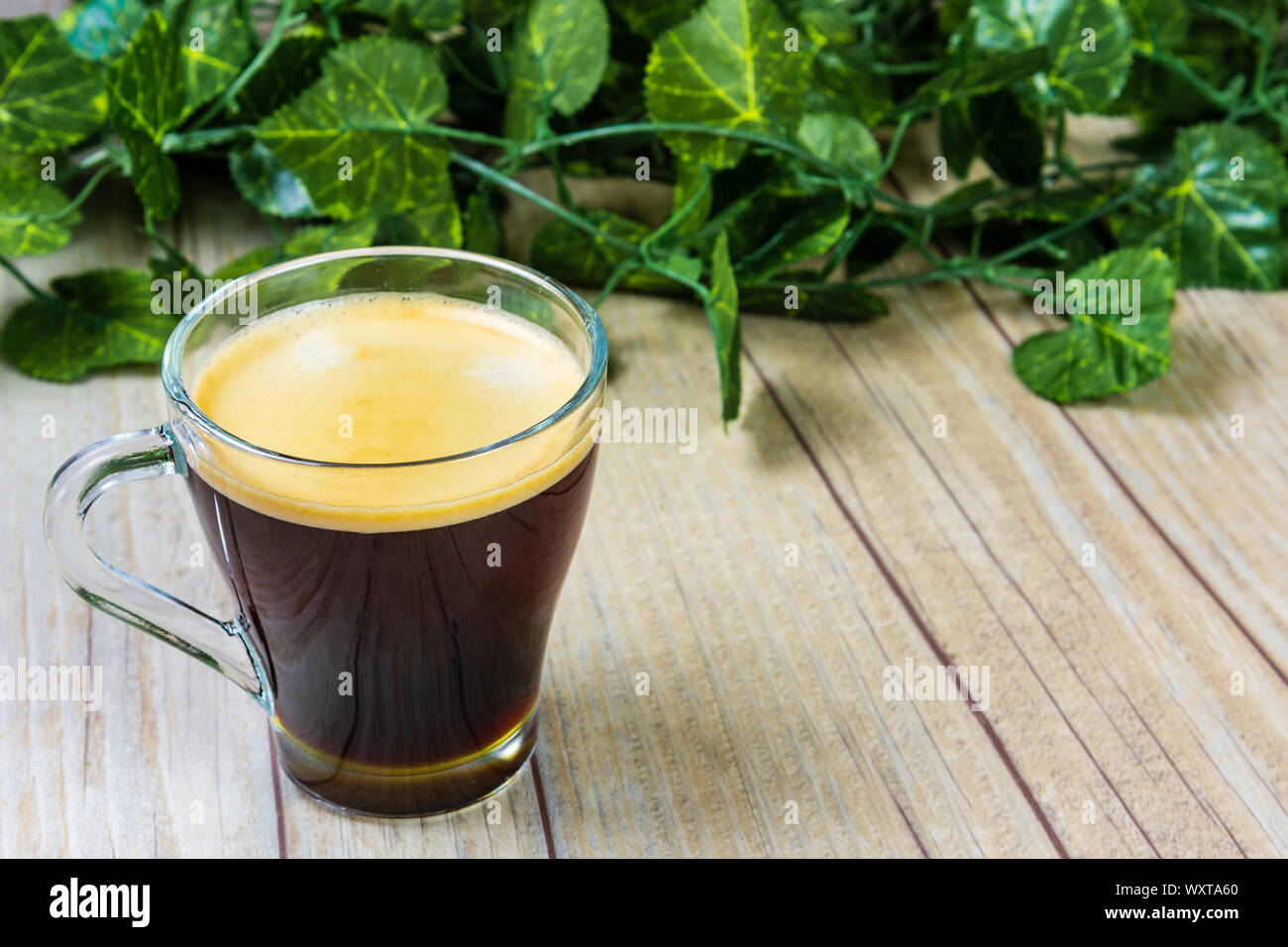 https://c8.alamy.com/comp/WXTA60/a-black-coffee-in-a-glass-on-a-wooden-background-WXTA60.jpg