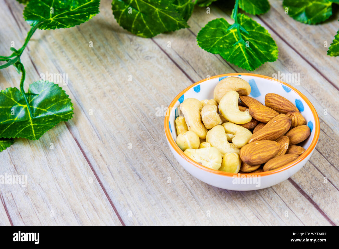Almonds and Cashews in a Bowl on a Wooden Background Stock Photo