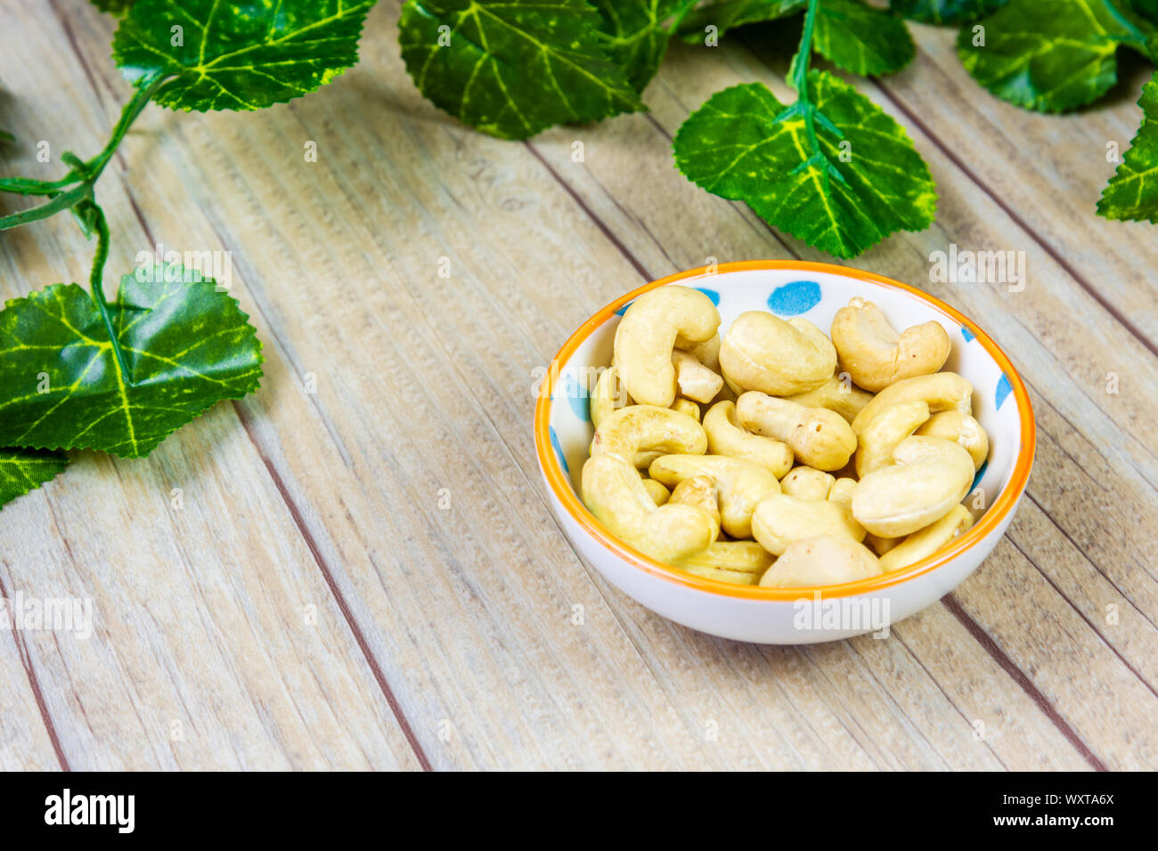 A Bowl of Cashews on a Wooden Background Stock Photo