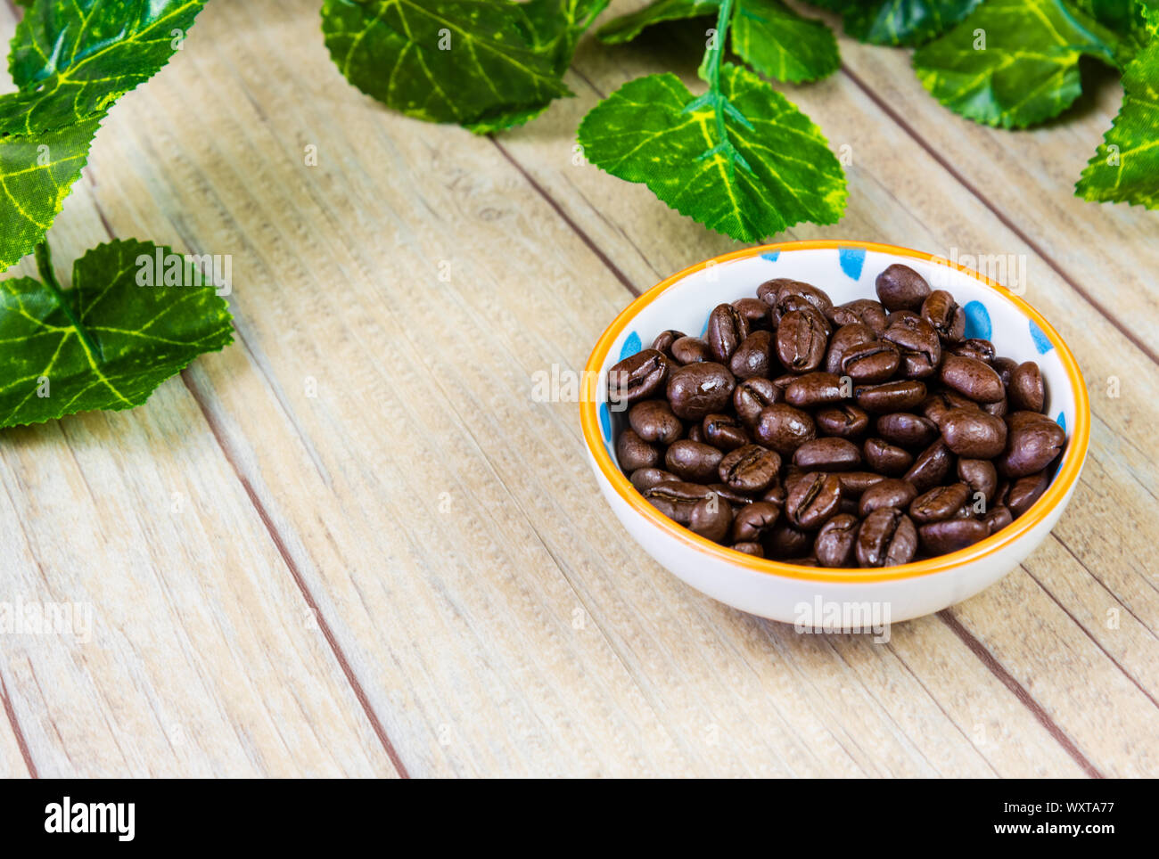 Coffee Beans in a Bowl on a Wooden Background Stock Photo