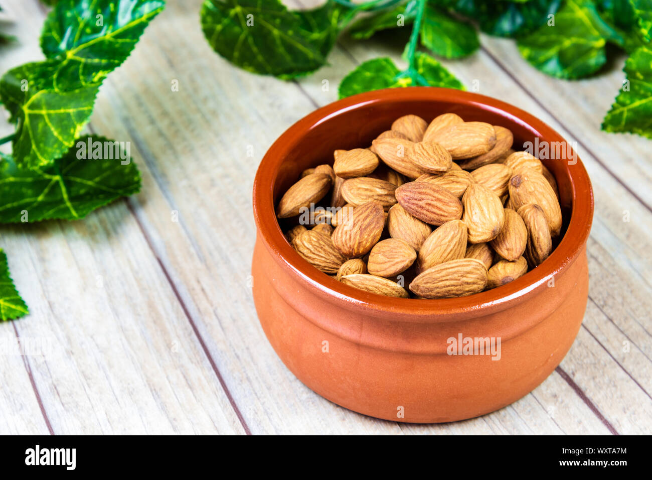 Almonds in a Bowl on a Wooden Background Stock Photo