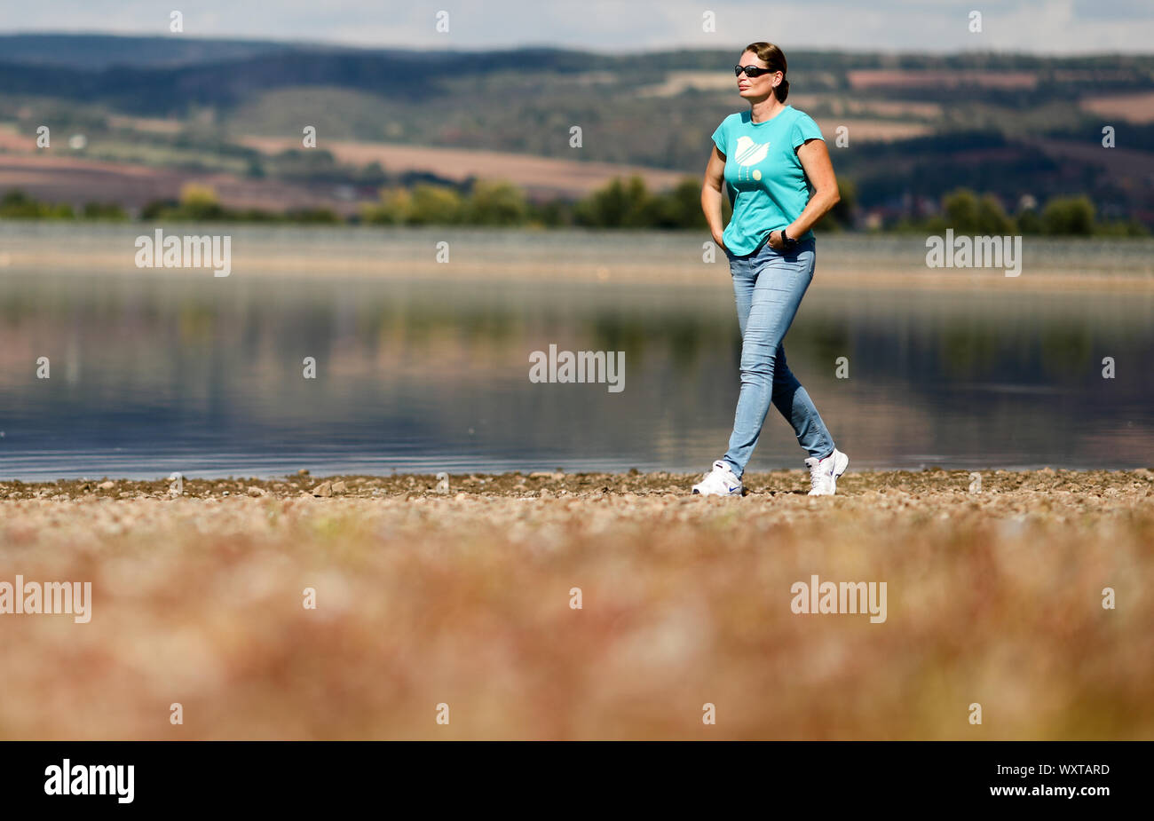 12 September 2019, Saxony-Anhalt, Kelbra: Former shot-putter Nadine Kleinert walks along the Kelbra reservoir. Lack of attractiveness for teenagers, hardly any TV presence, frustrated coaches and the often lacking financial security of the athletes: The former world-class shot-putter does not give the Olympic core sport a great future. 'If things continue like this, athletics will be dead in ten years - and the DLV will no longer exist,' said the 2004 Olympic silver medallist in an interview with the German Press Agency. (to dpa 'Ex-ball-putter Kleinert: 'This is no longer my athletics!') ») P Stock Photo