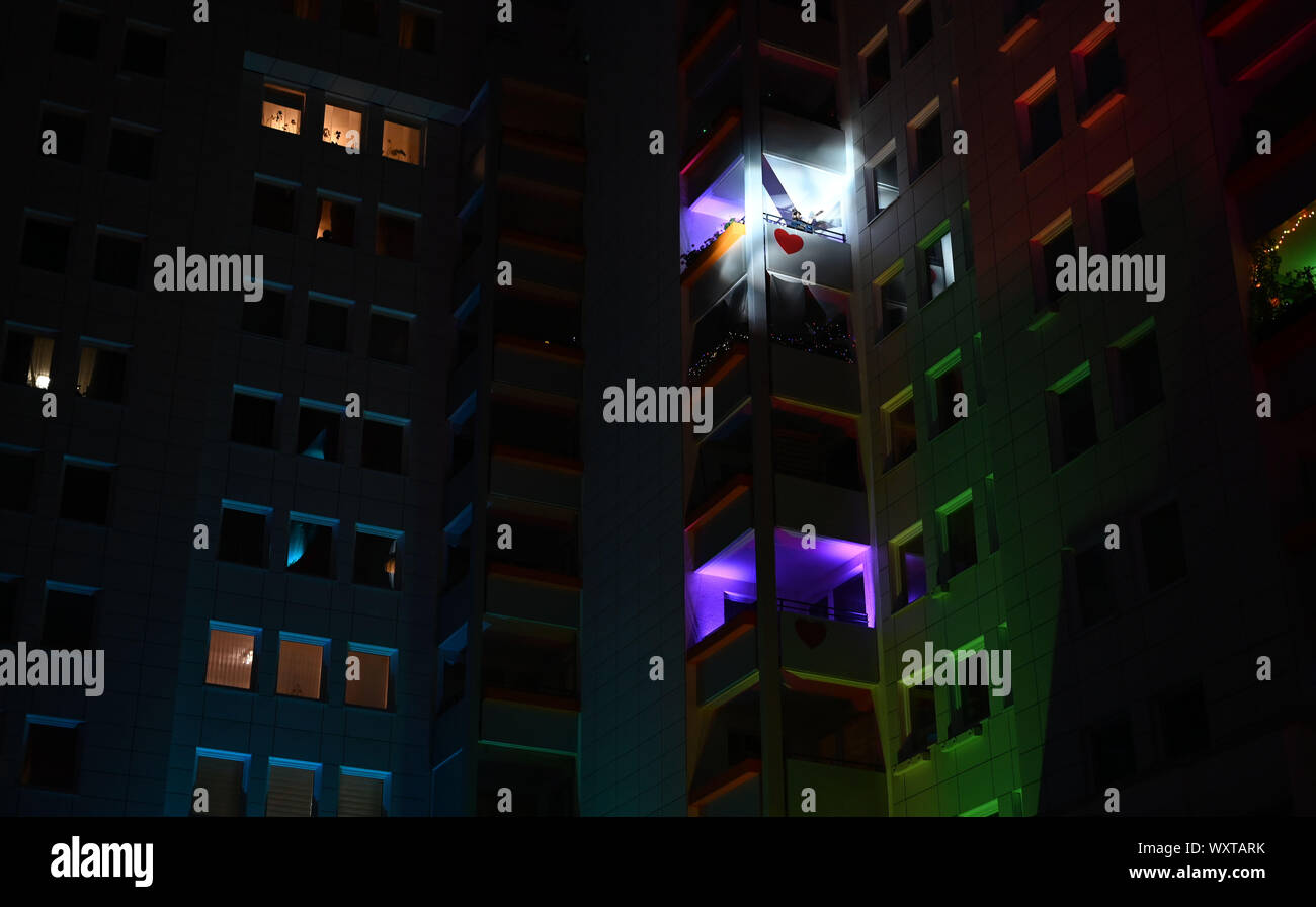 Bremen, Germany. 17th Sep, 2019. At the cultural event and neighbourhood festival 'Singende Balkone' (Singing Balconies), the high-rise façade shines brightly, a balcony with a singer is brightly illuminated. The music event is organised with the Bremen housing association GEWOBA and takes place in the Bremen district of Osterholz-Tenever, which is known for its high-rise housing estates. Credit: Carmen Jaspersen/dpa/Alamy Live News Stock Photo