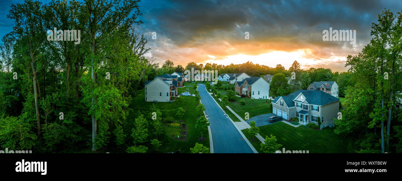 American luxury real estate single family houses with brick facade, solar power roof new construction Maryland street neighborhood with sunset Stock Photo